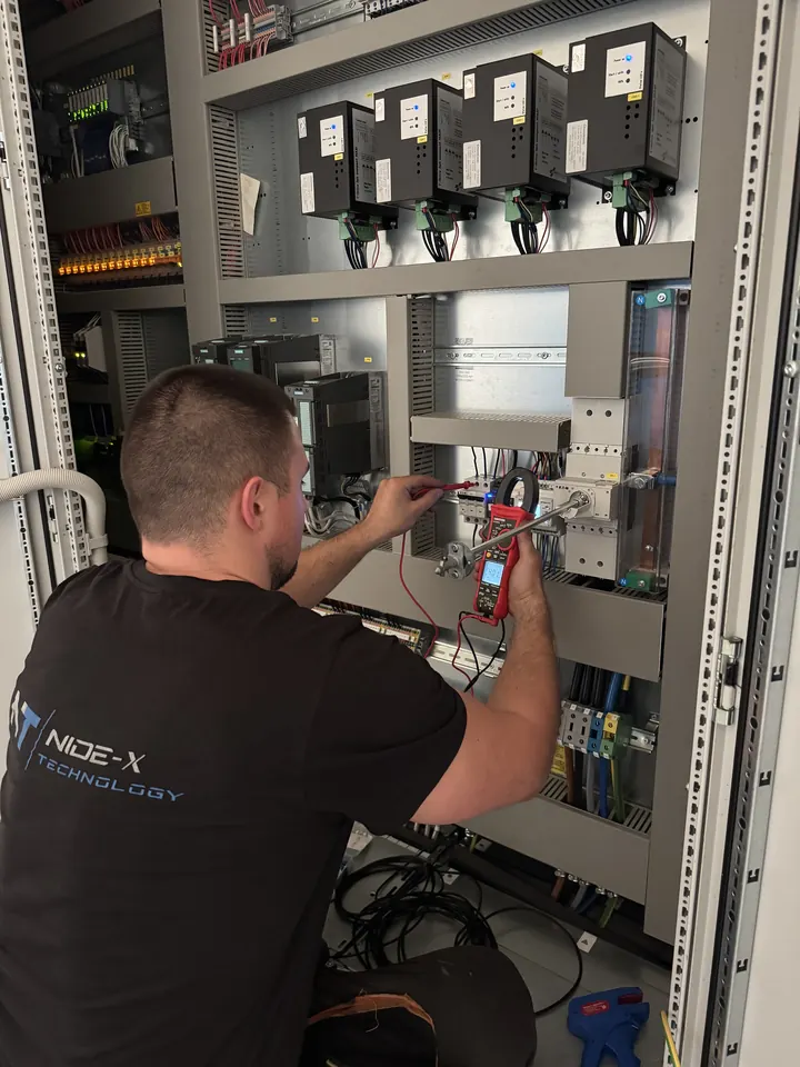 Technik overuje meraciu techniku v rozvádzači multimetrom
